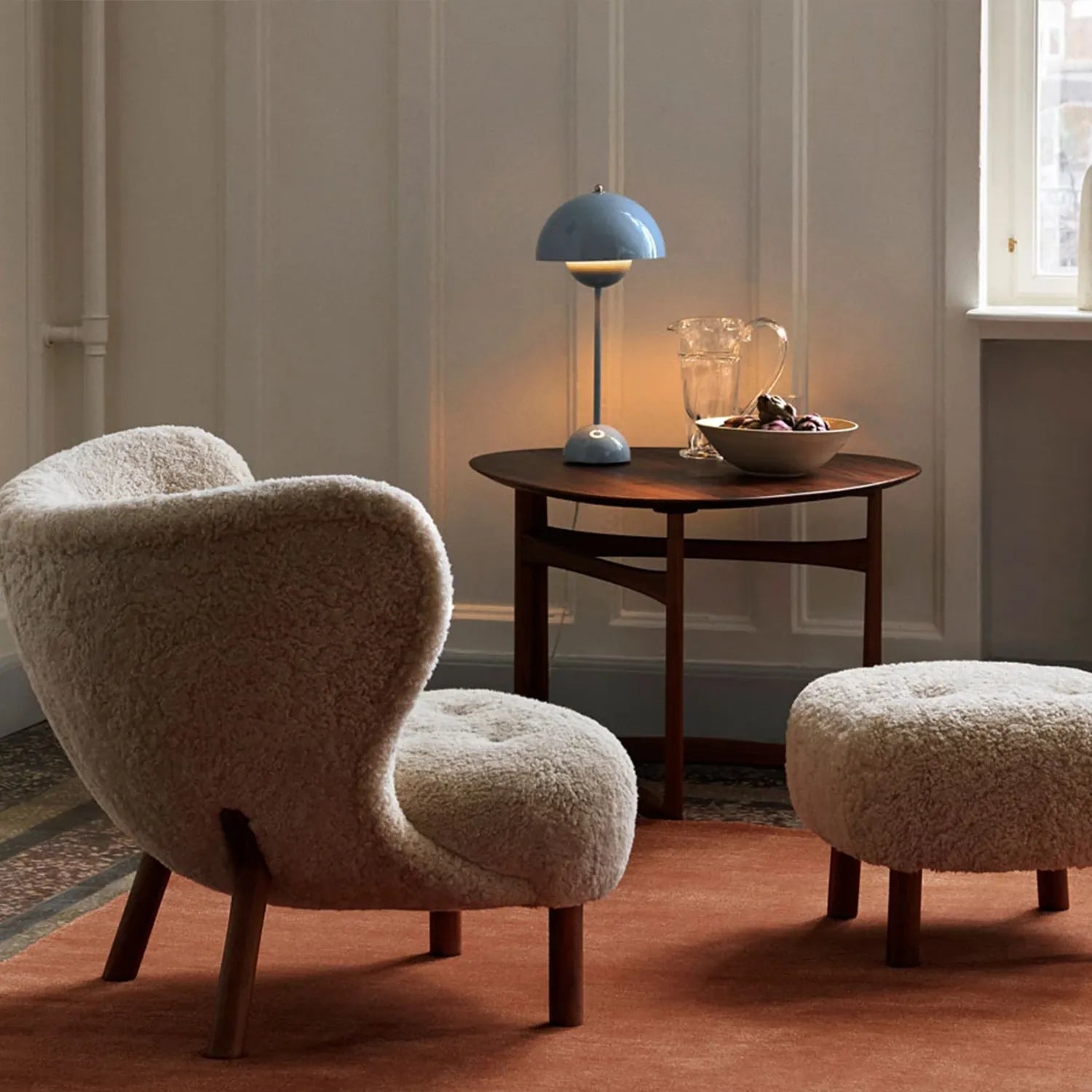 Little Petra Lounge Chair and Ottoman in Danish design, faux sheepskin upholstery, cherry wood legs, cozy modern interior setting.