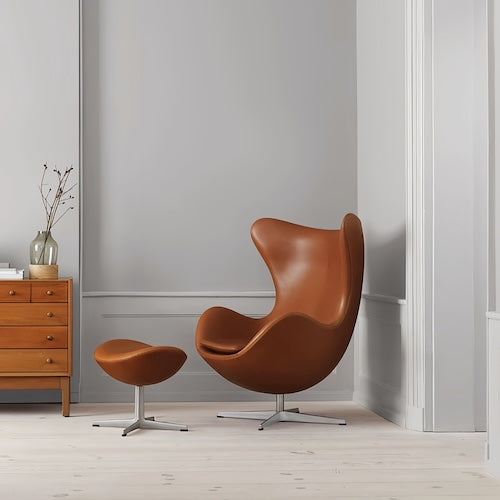 Egg Chair with stool in brown leather and sleek metal base, modern interior design - sparkledecor.com