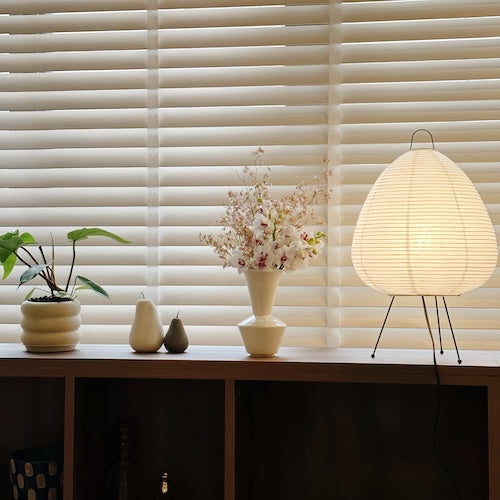 Traditional Japanese rice paper lamp on a wooden table, showcasing Wabi-sabi style design with warm light.