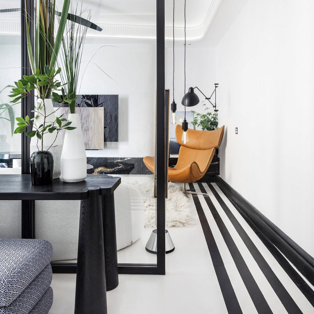 Imola Lounge Chair with Footstool in modern living room setting, showcasing Danish craftsmanship and ergonomic design.